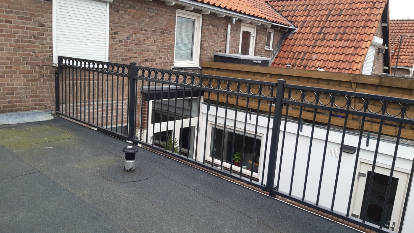 Het balkonhekwerk loopt langs de rand van het dakterras