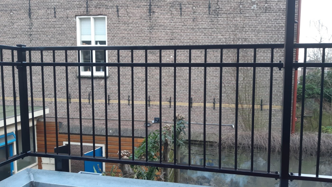 Het zwarte balkonhekwerk langs de rand van het dakterras in Gouda
