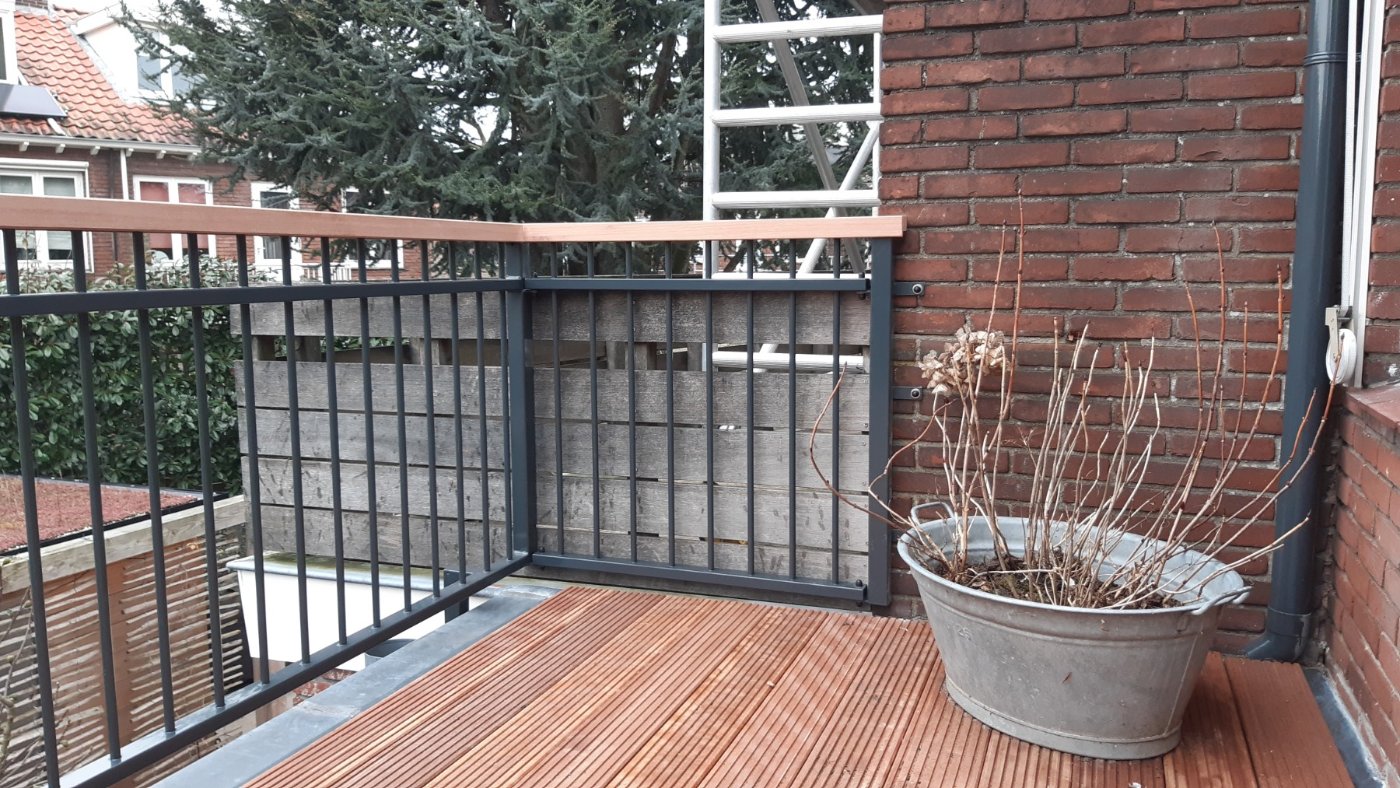 Antracietgrijs balkonhekwerk met houten handregel op een dakterras in Utrecht