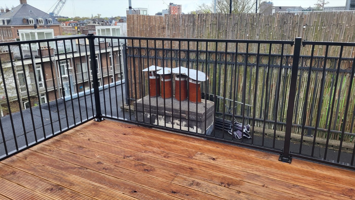 Hoek van het dakterras met het zwarte spijlenhek