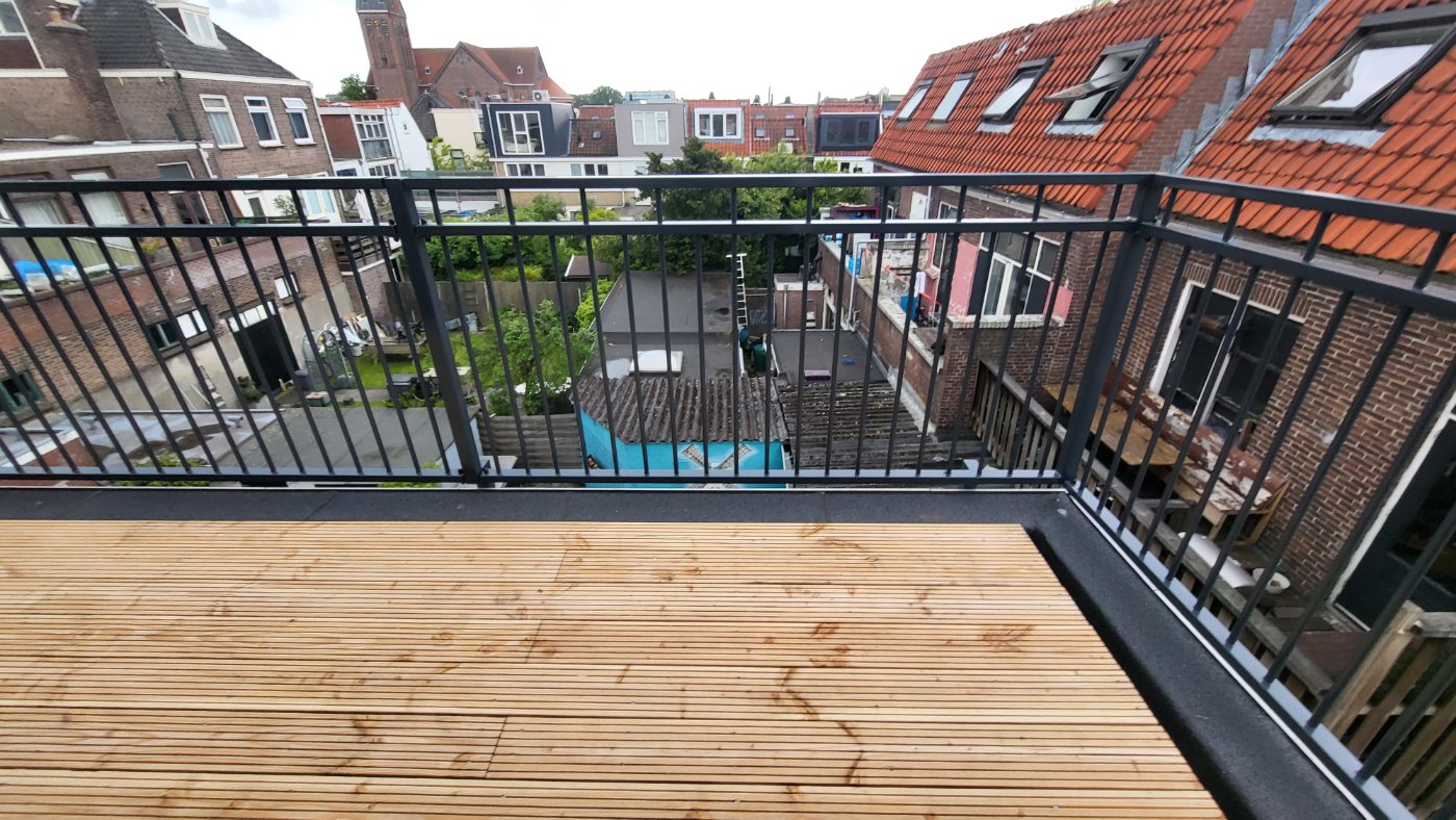 Stalen balustrade model A05 in RAL 7016 rond een dakterras met uitzicht over de daken van Delft