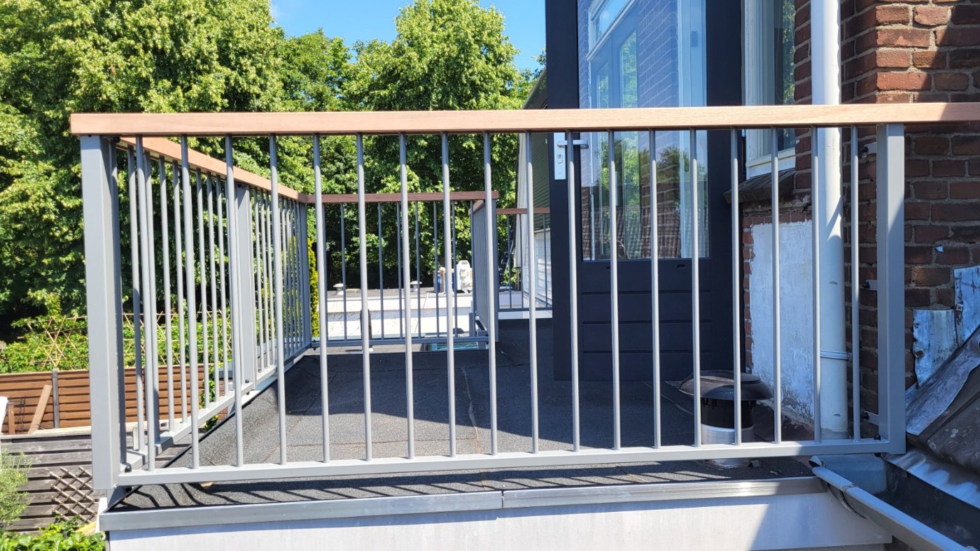 Balustrade A03 in RAL 7037 met houten handregel op een dakterras in Deventer