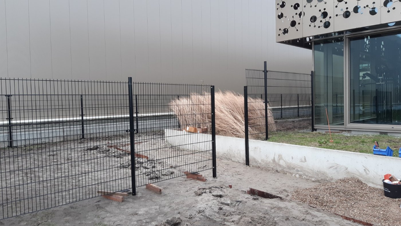 Zwart dubbelstaafmat hekwerk langs een pand in Almere