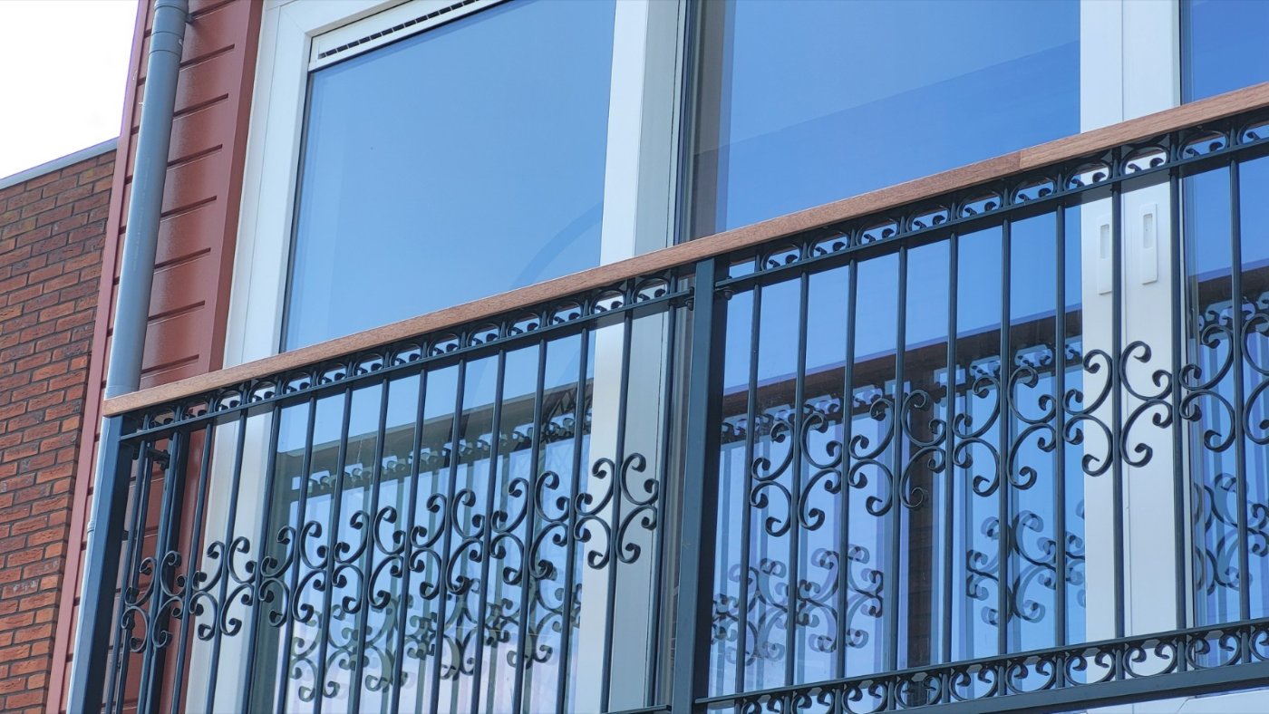 Detail van het krulwerk in het Franse balkonhek