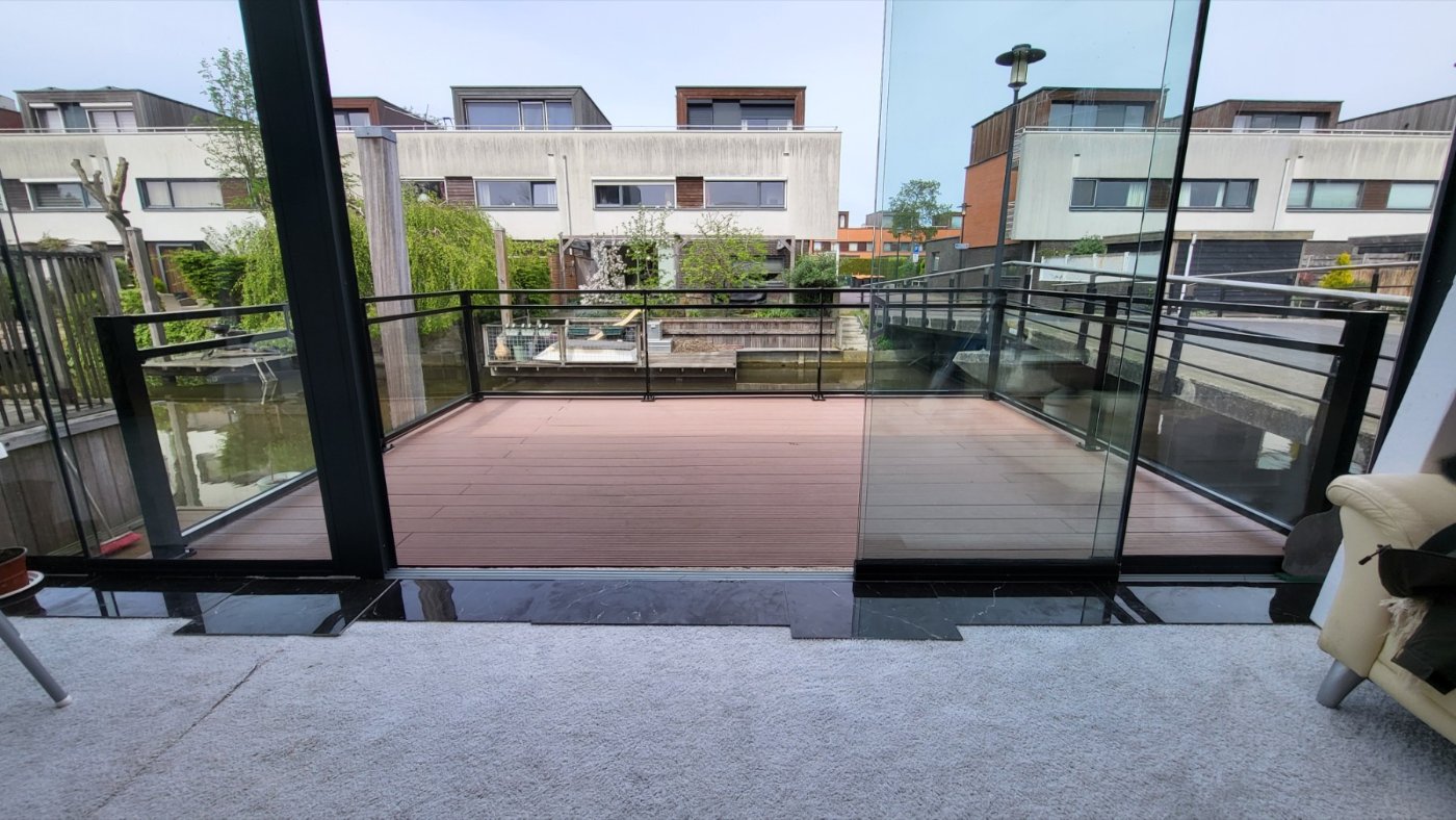 Zicht vanaf het terras door de glazen balustrade