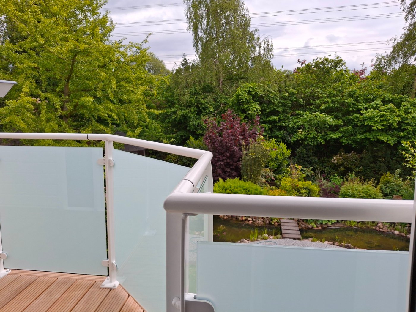 Uitzicht over de tuin vanaf het dakterras, over de handregel van de balustrade heen