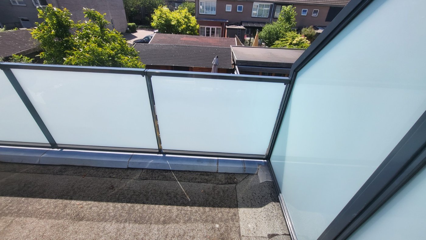 Hoekdetail van de glazen balustrade met matglas in het stalen frame
