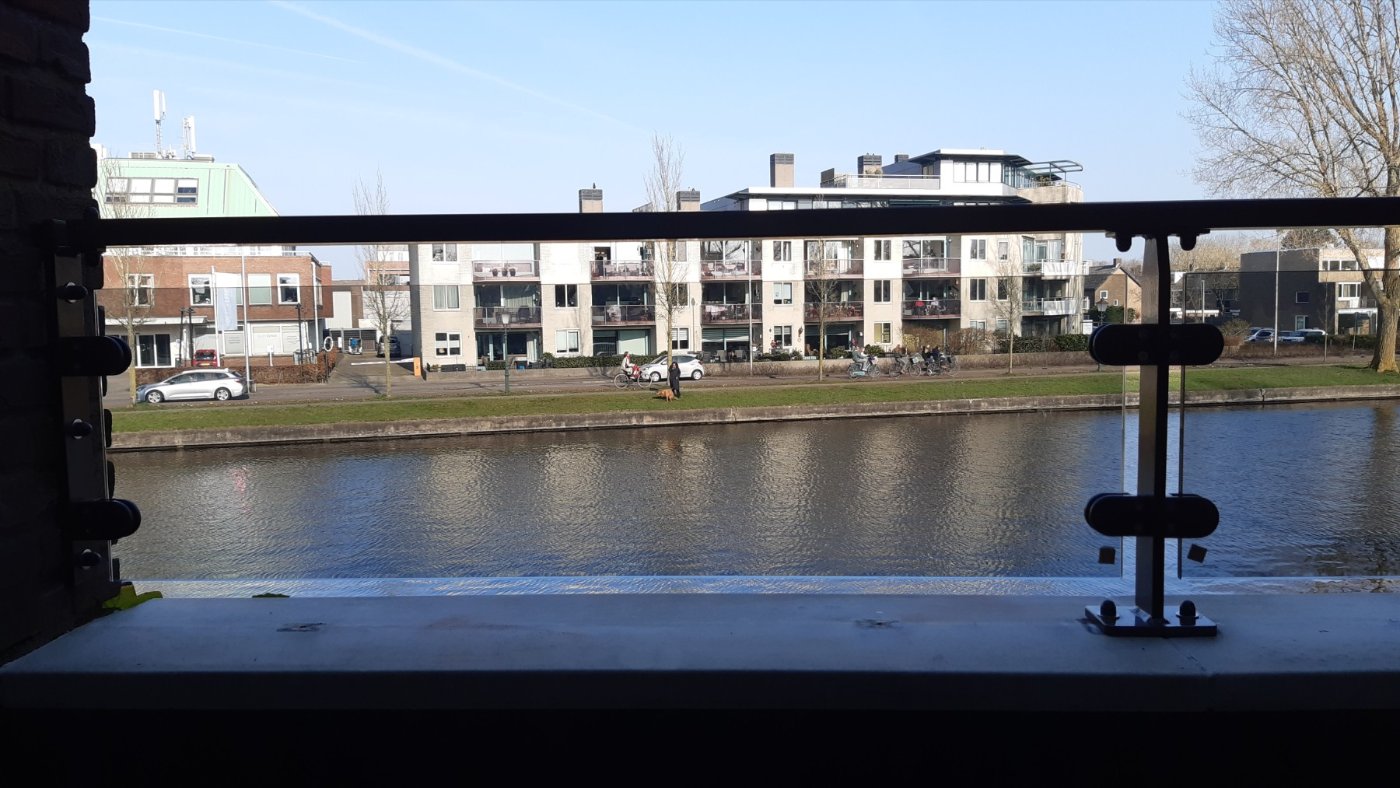 Uitzicht over het water door de glazen balustrade