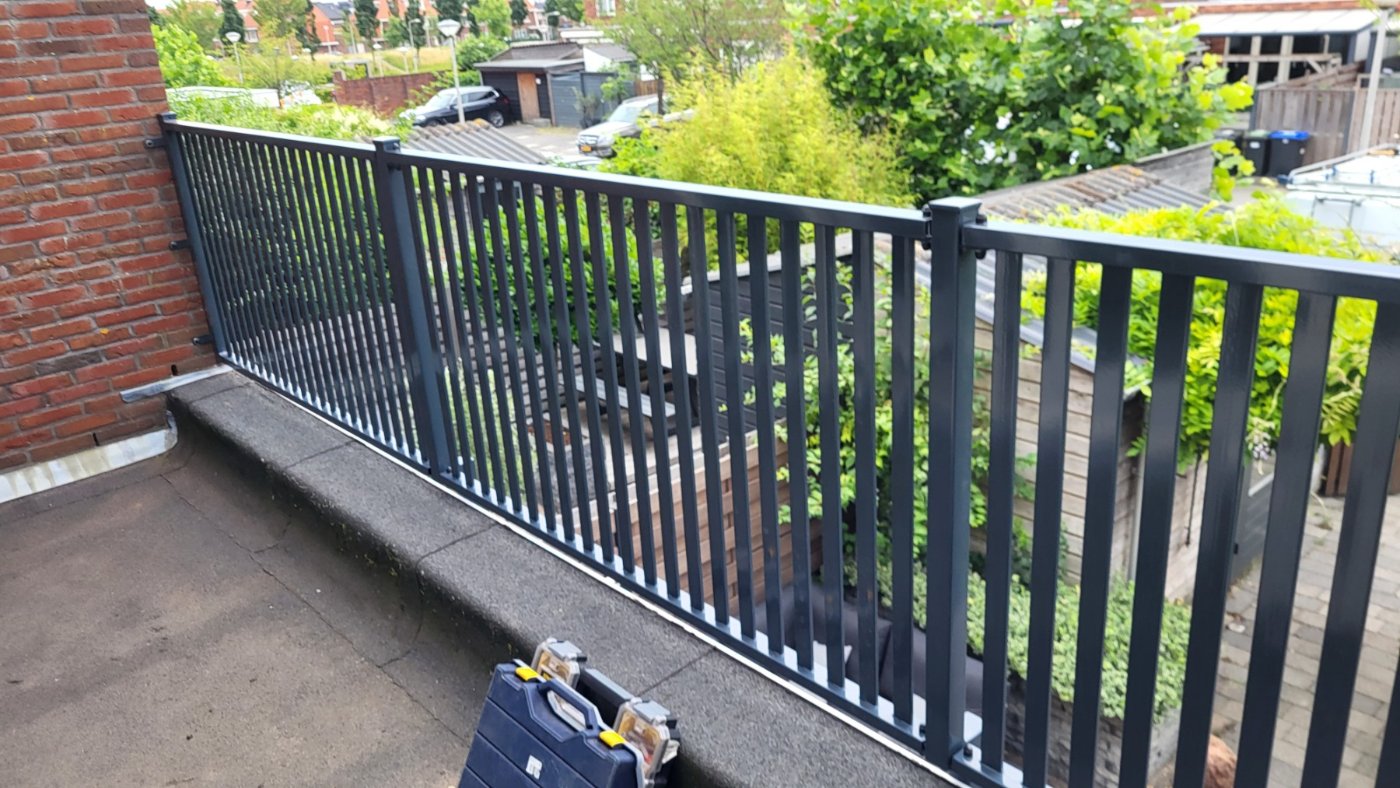 Antracietgrijze lamellenbalustrade langs de rand van het dakterras