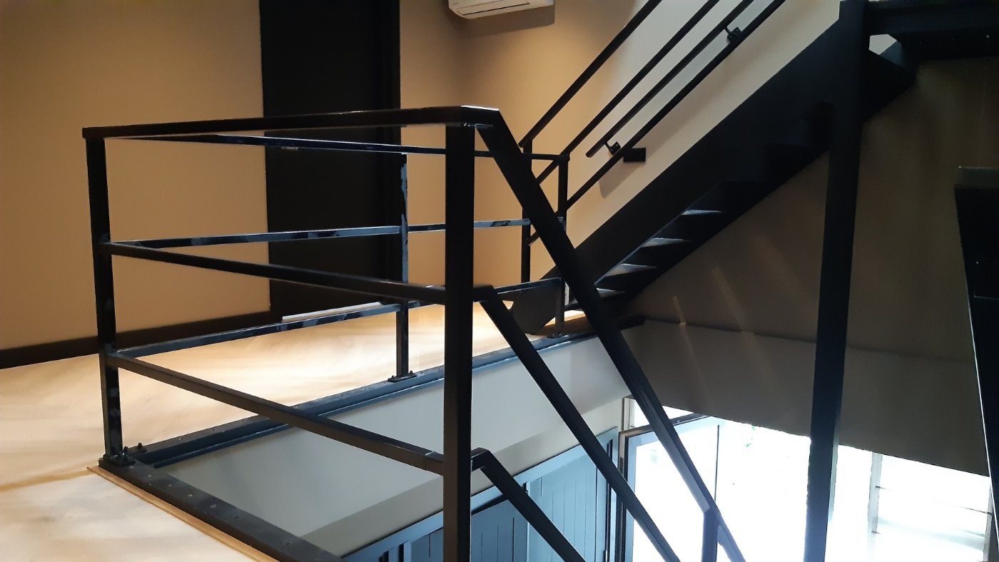 Zwart stalen leuningwerk rond het trapgat met open trap in een woning in Waddinxveen