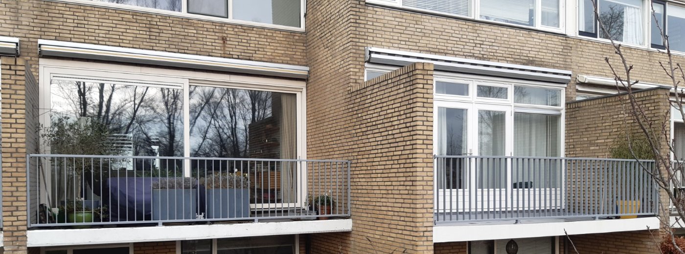 De balkons van de buren met hetzelfde hekwerk in lichtgrijs