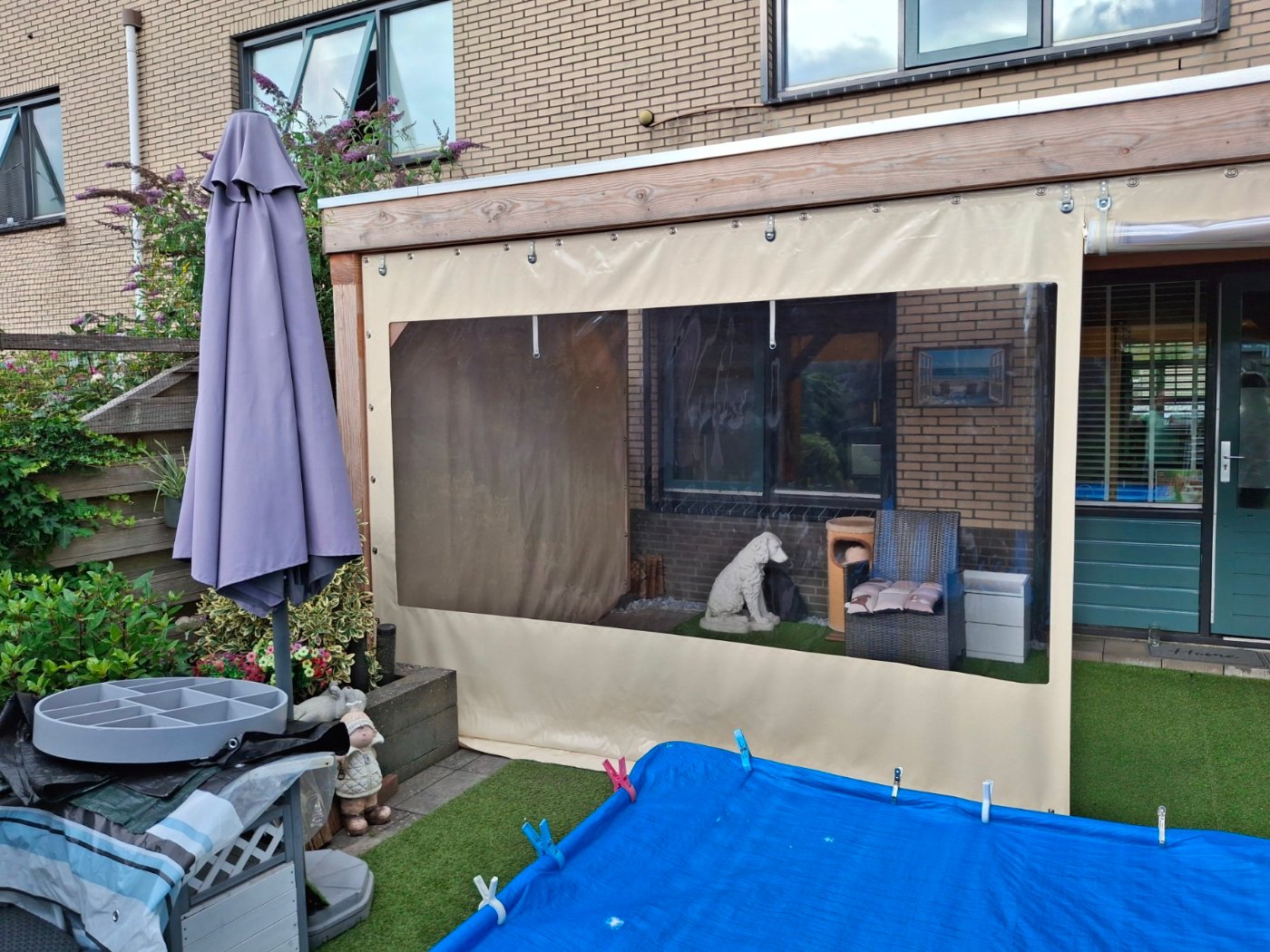 Creme verandazeil met groot raam aan de voorzijde van een houten veranda in Almere