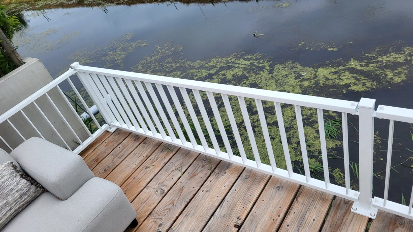 Witte balustrade langs de waterkant van het houten terras