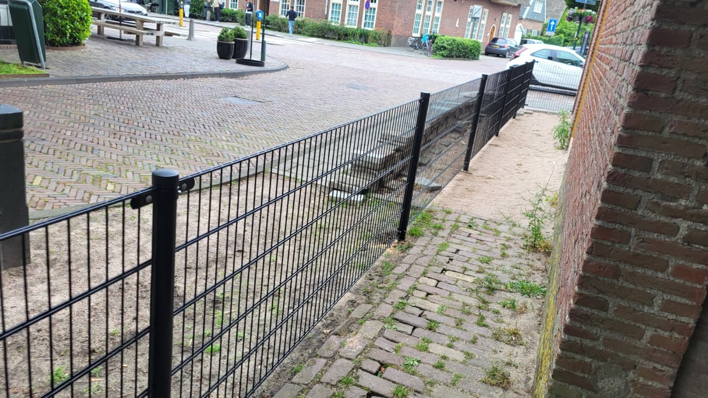Het hekwerk volgt de perceelgrens langs de bestrating