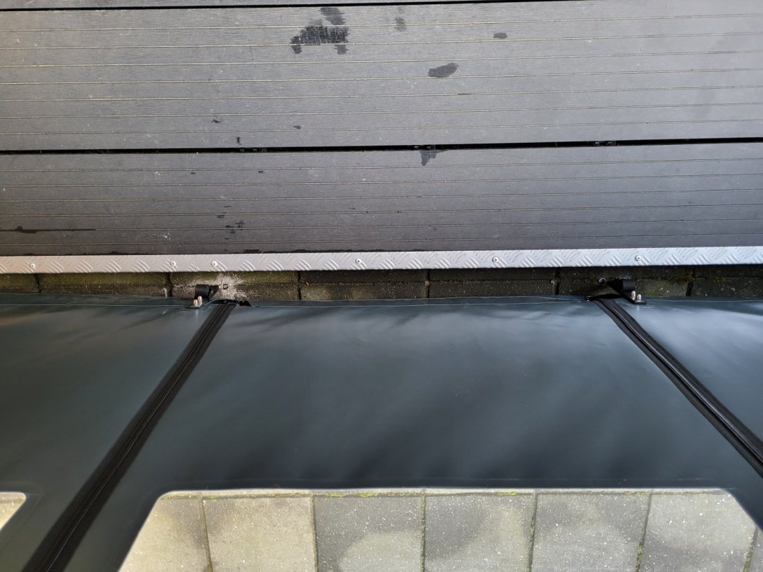 Opgerold verandazeil onder de dakrand