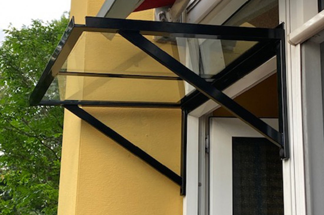 Stalen deurluifel met glasplaat boven een voordeur